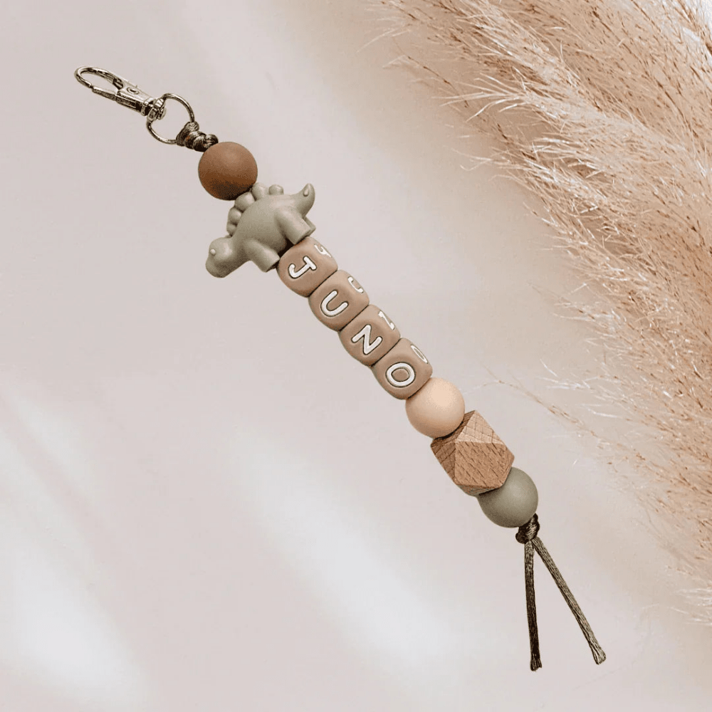 Green and brown keychain with a dino name