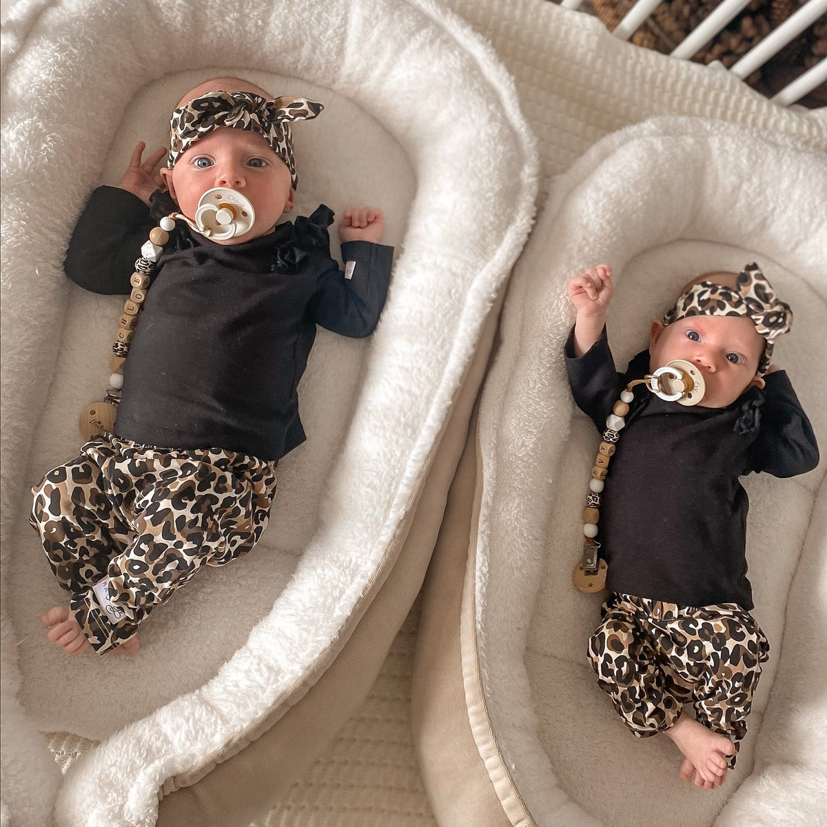 Twee baby's met matching luipaardprint outfit en een Speenkoorden met naam