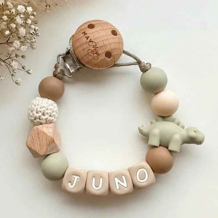 Green and brown pacifier clip with dinosaur name